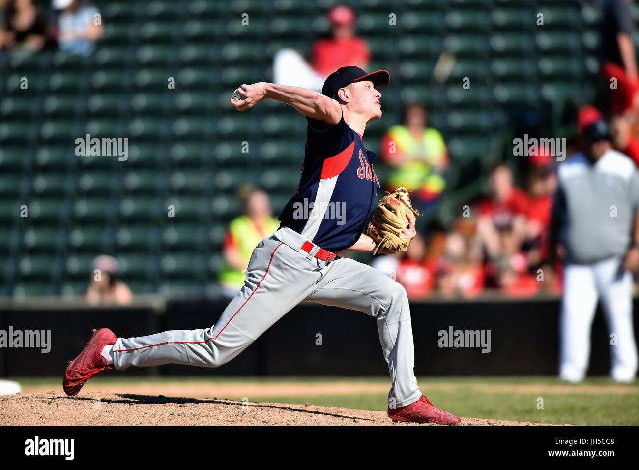 Pitcher delivering a pitch to an opposing hitter during a high school baseball game. USA. Stock Photo