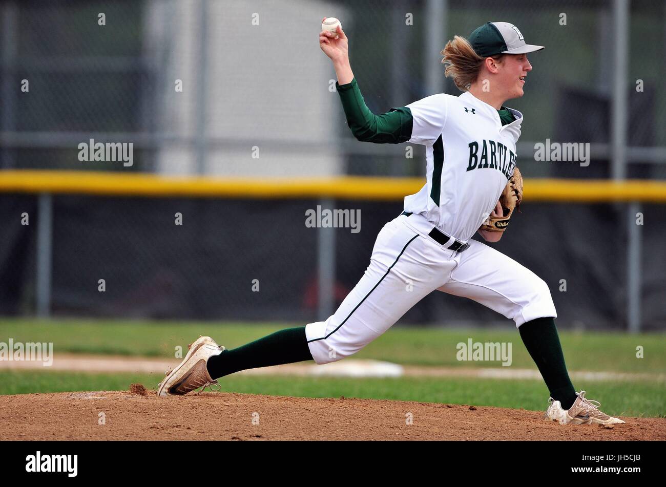 Pitcher delivering a pitch to an opposing hitter during a high school