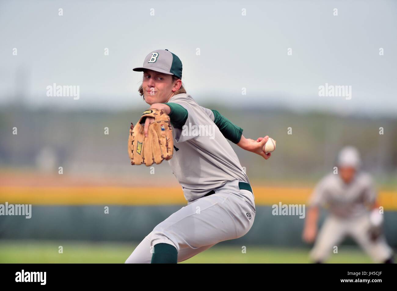 Pitcher delivering a pitch to an opposing hitter during a high school