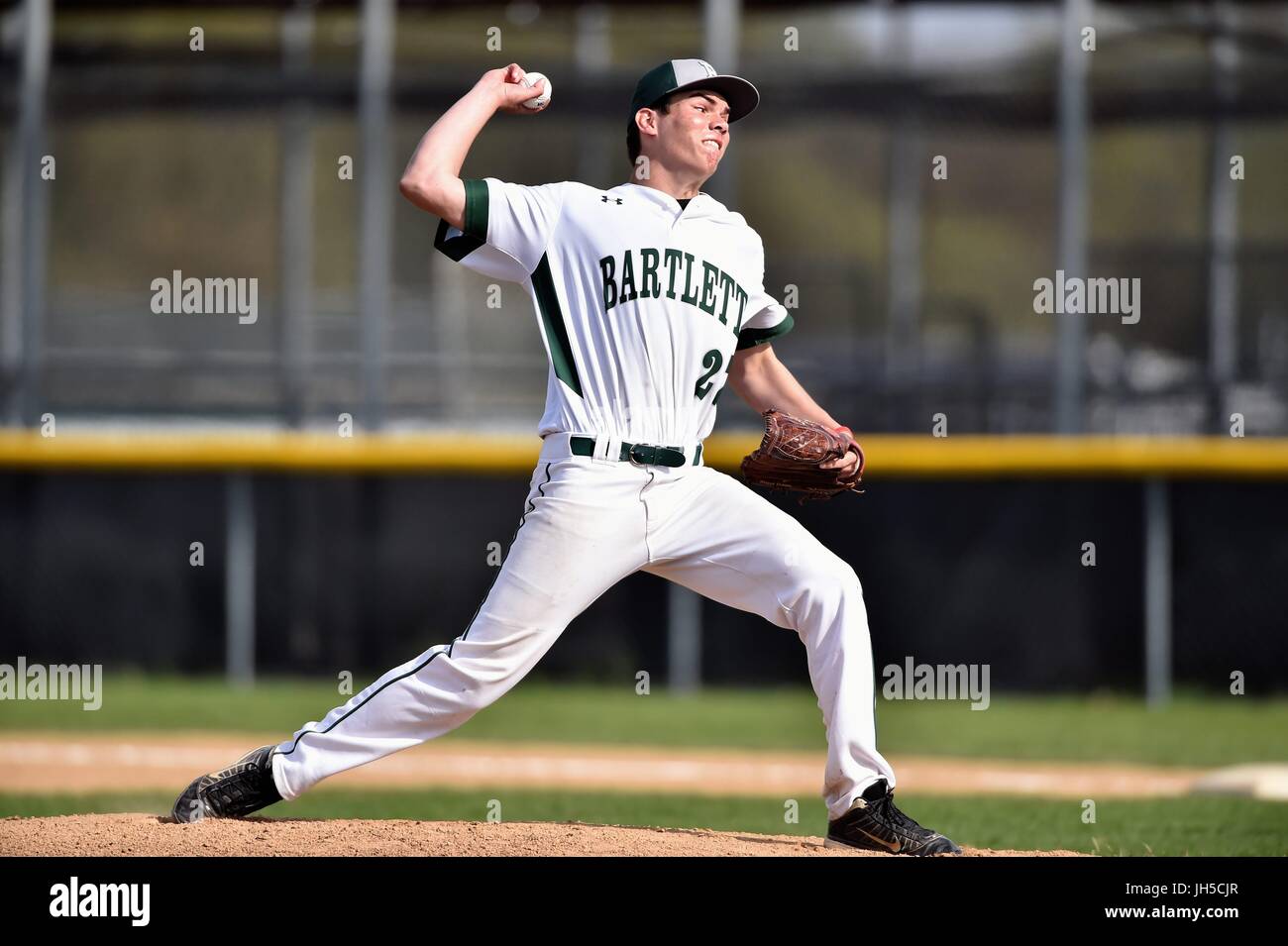Pitcher delivering a pitch to an opposing hitter during a high school
