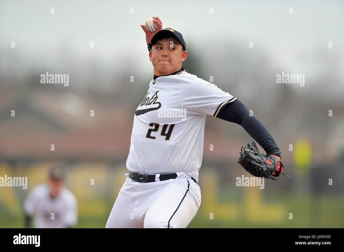 Pitcher delivering a pitch to an opposing hitter during a high school