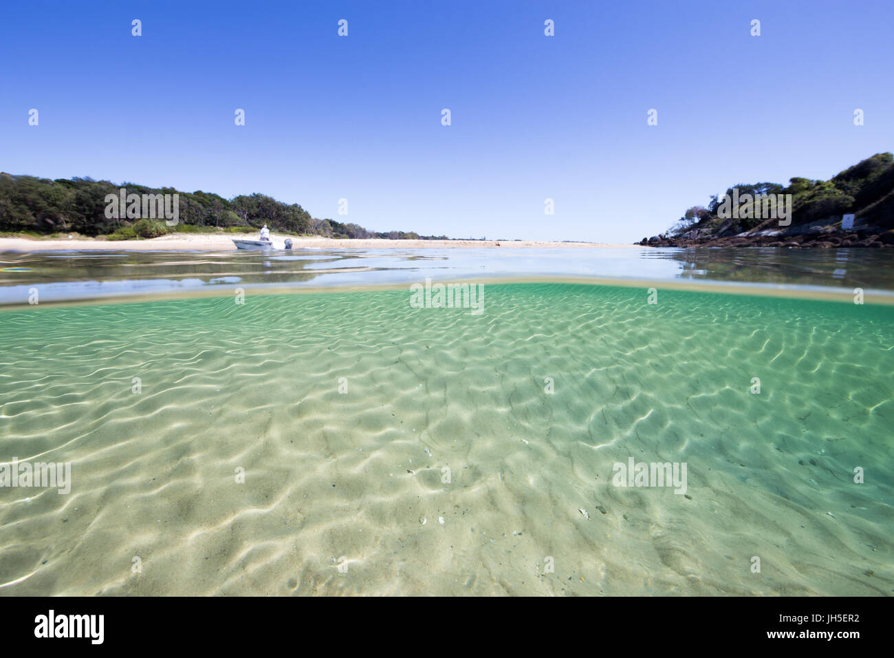 An under over split image of a beautiful, pristine beach scene with crystal clear turquoise water. Stock Photo