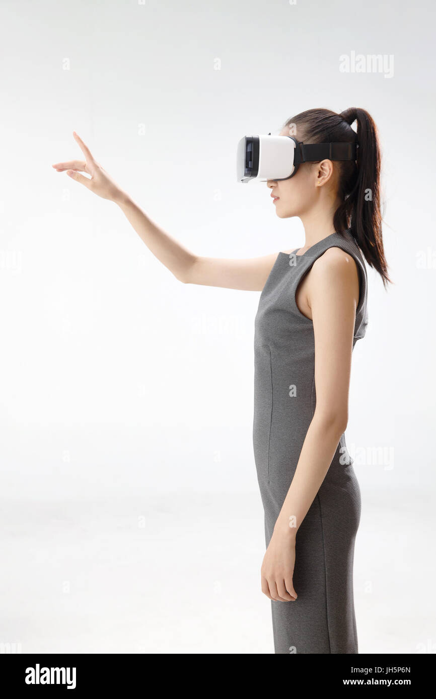 Young woman using virtual reality headset Stock Photo - Alamy