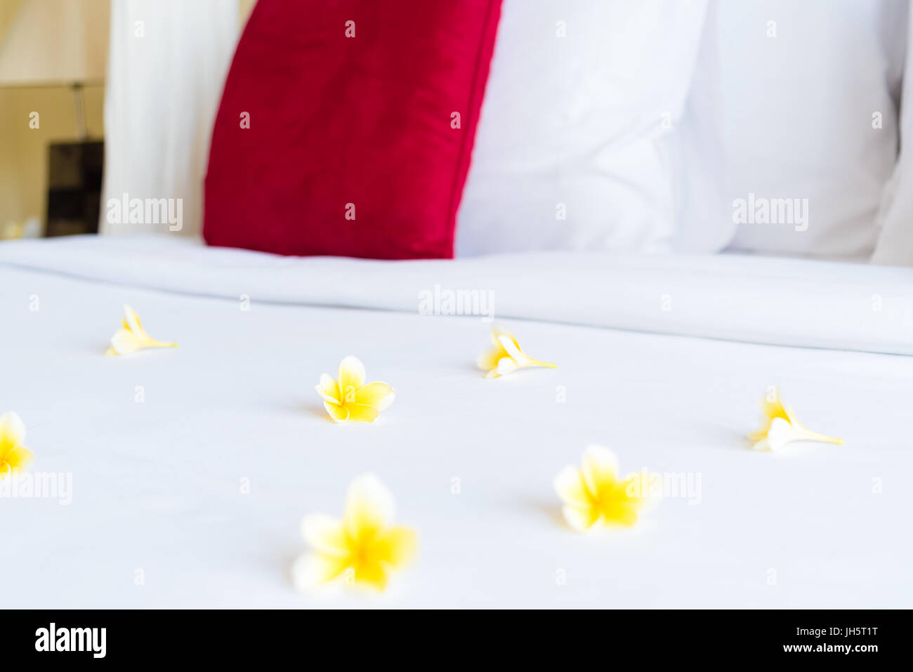 Hotel room with bed and flower arrangement, copy space for text Stock Photo