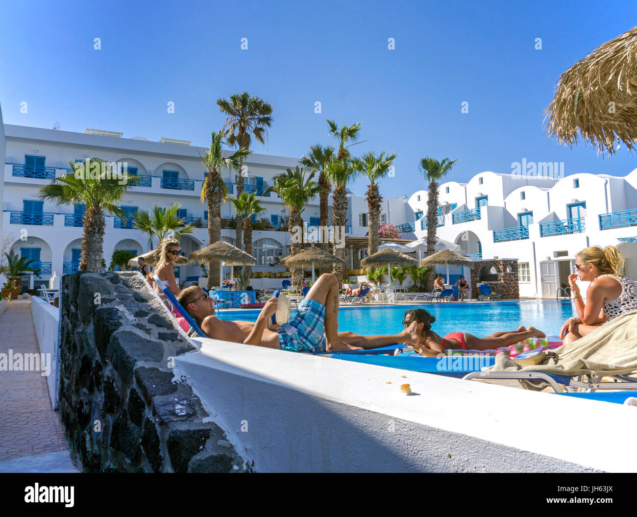 Urlauber relaxen am Pool, Hotel am Kamari Beach, Santorin, Kykladen, Aegaeis, Griechenland, Mittelmeer, Europa | People relaxing at the pool, hotel at Stock Photo