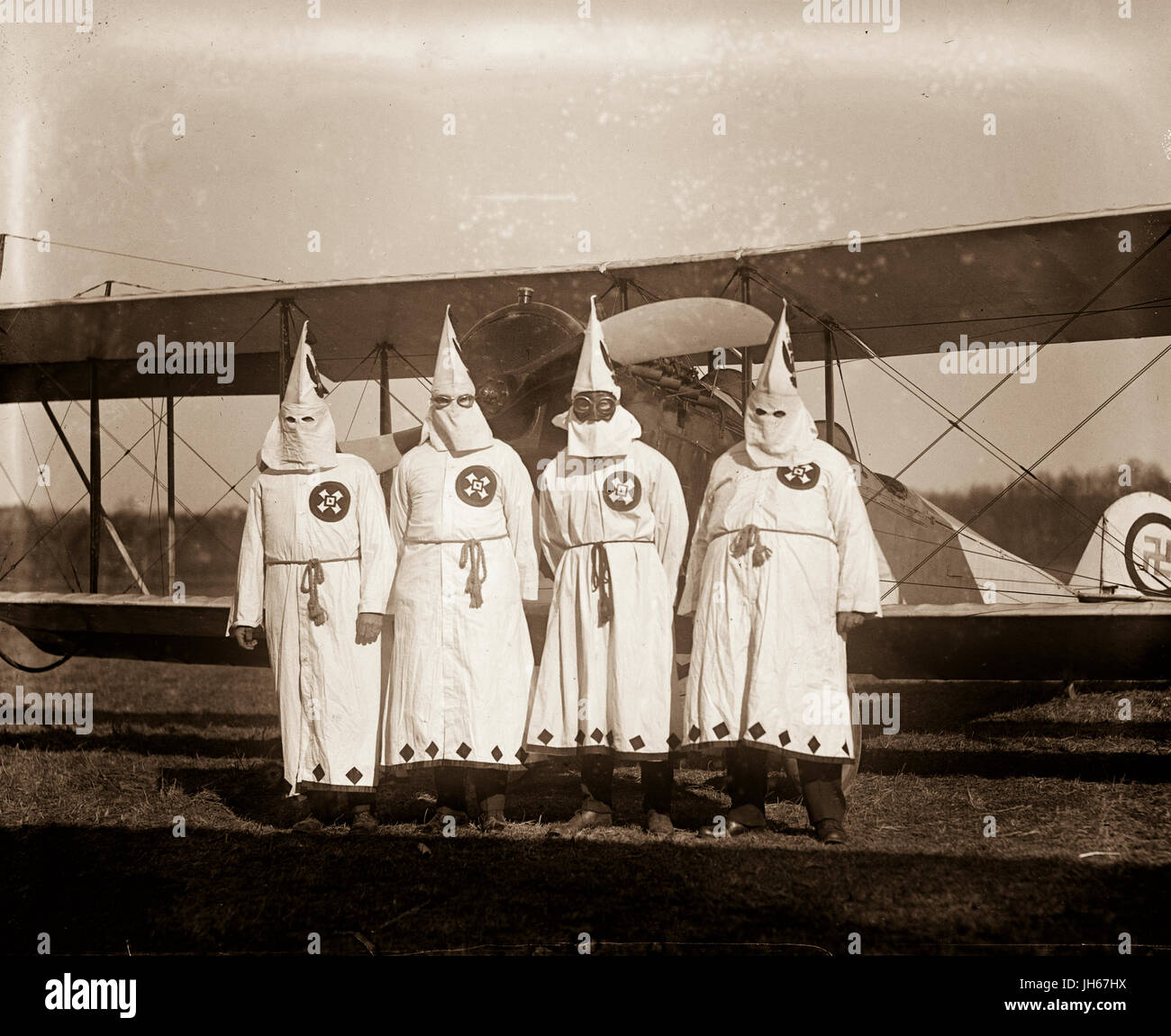 Ku Klux Klansmen use a biplane to drop and distribute KKK leaflets over the American countryside. Stock Photo