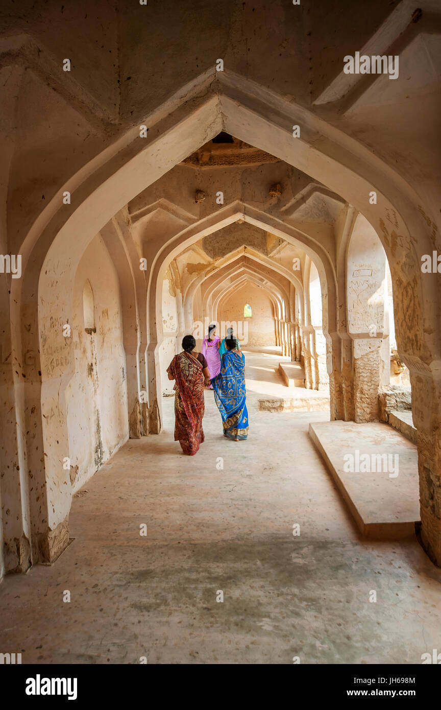 Indian people walking on the corridor of the Queen's Bath Palace, Hampi, Karnataka, India Stock Photo