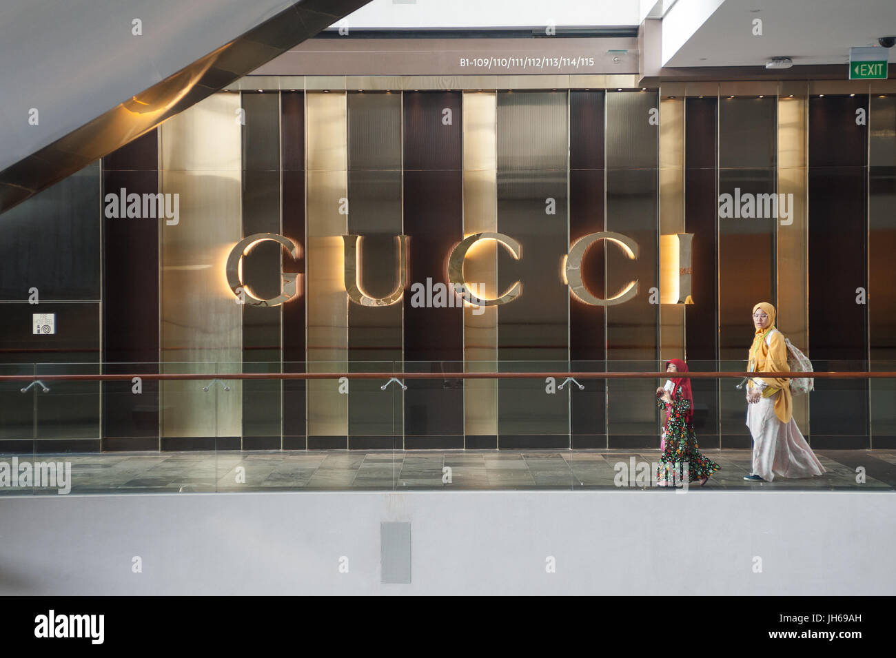 25.05.2017, Singapore, Republic of Singapore, Asia - A woman and her daughter walk by a retail shop of the luxury brand Gucci in 'The Shoppes' mall. Stock Photo