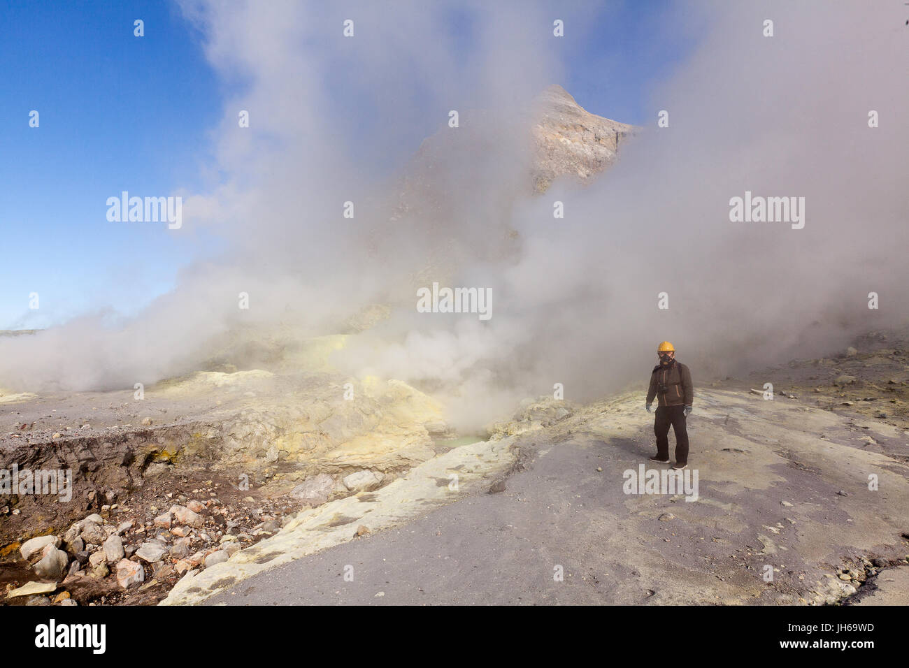 Tourist wearing a gas mask at a sulphur vent on White Island, Bay of Plenty, New Zealand Stock Photo