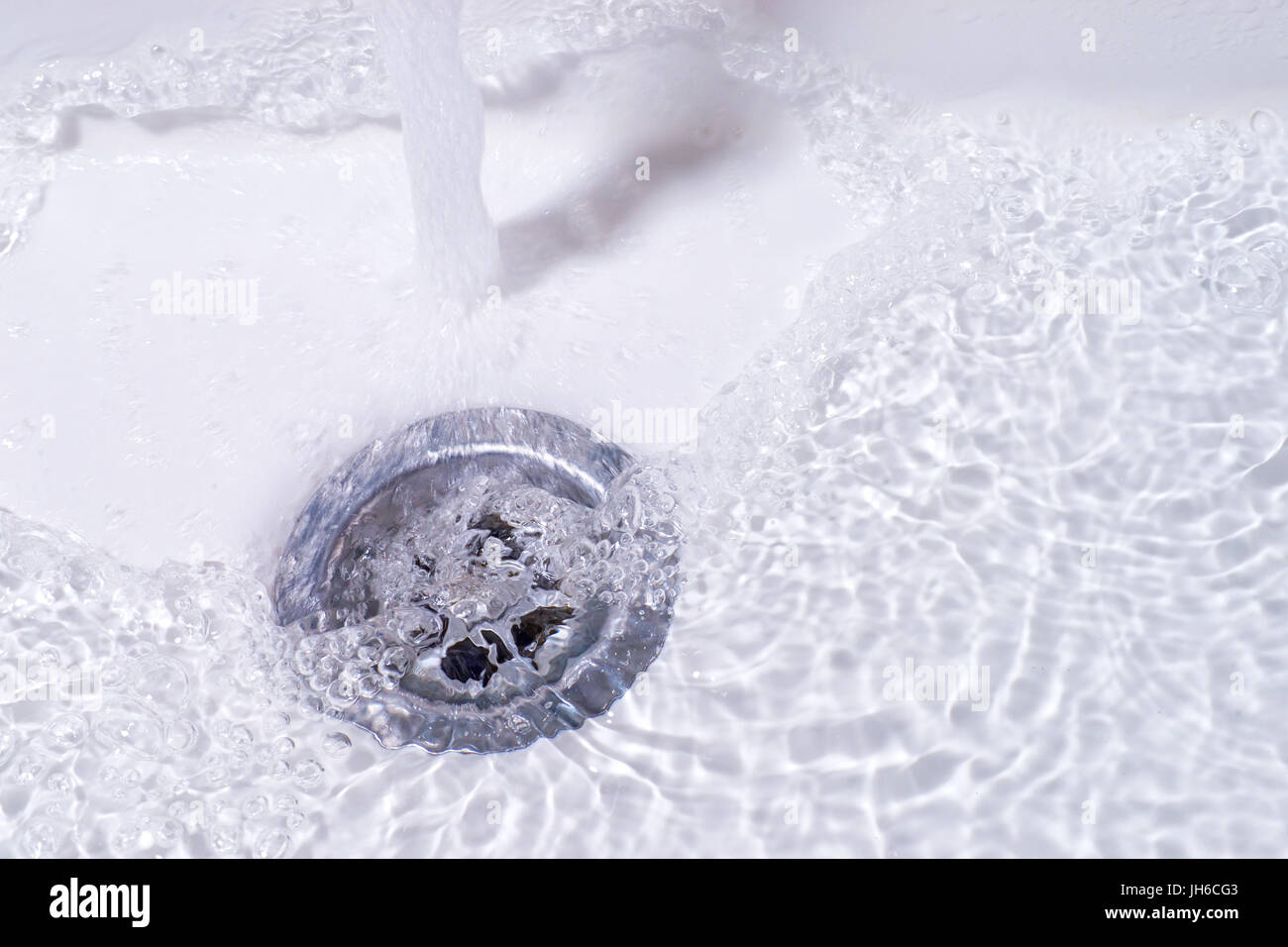 Water running down in the drain. Bathroom sink close up Stock Photo