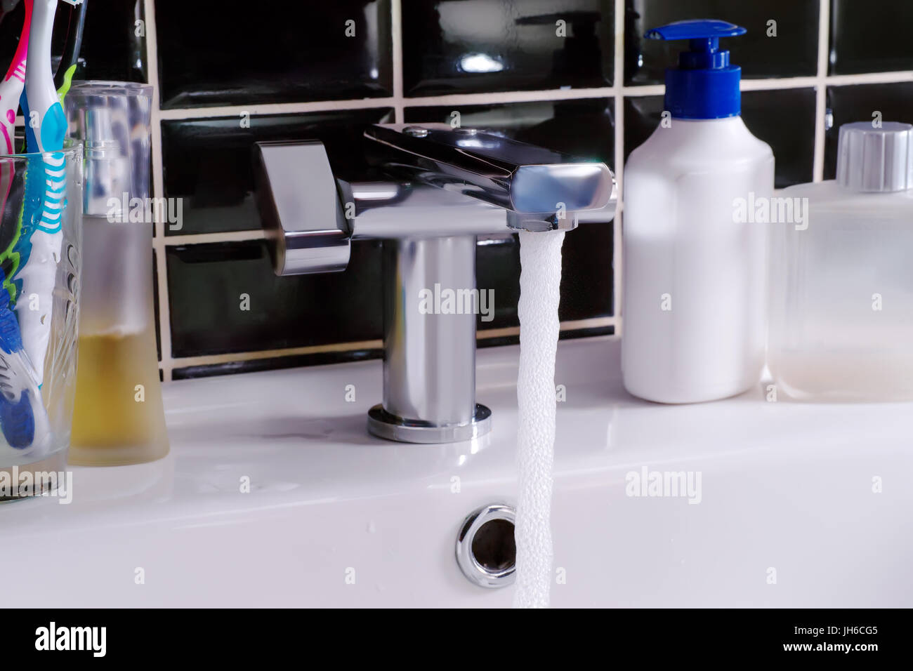 Modern water tap, running water and hygiene objects. Bathroom scene Stock Photo