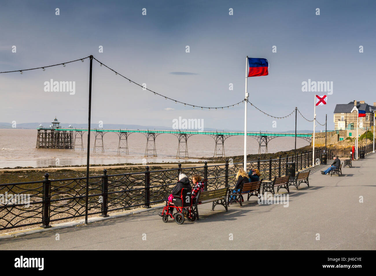 A lady in a wheelchair gazes at the restored Victorian pier at Clevedon on the Bristol Channel, North Somerset, England, UK Stock Photo