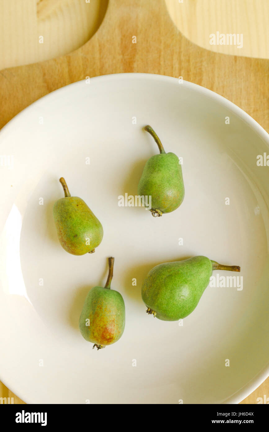 Pears on plate, green fruit on the table Stock Photo