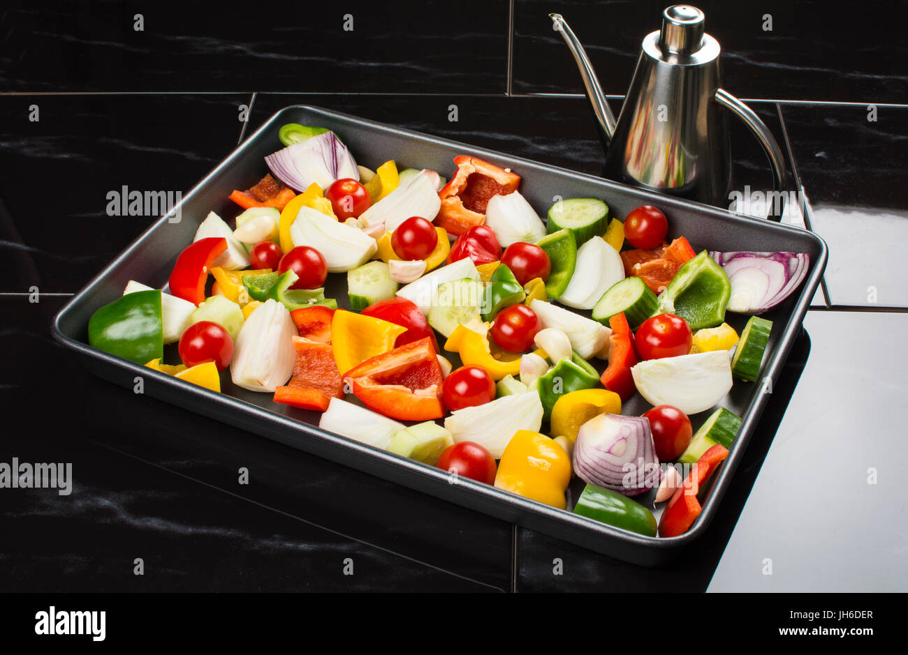 A tray of chopped  fresh vegetables, ready to be oven roasted Stock Photo