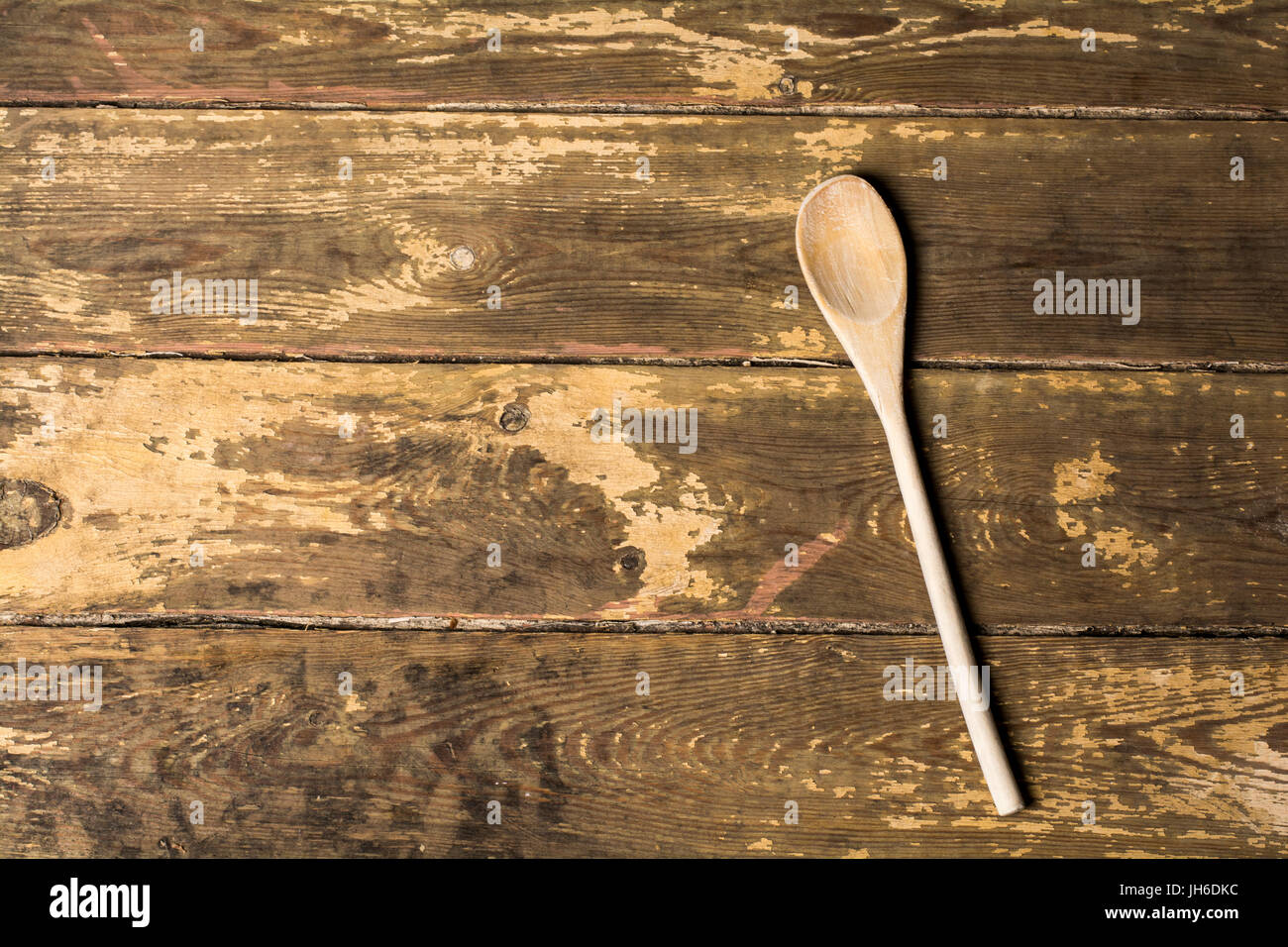 Wooden spoon on a weathered boards background with space for type Stock Photo
