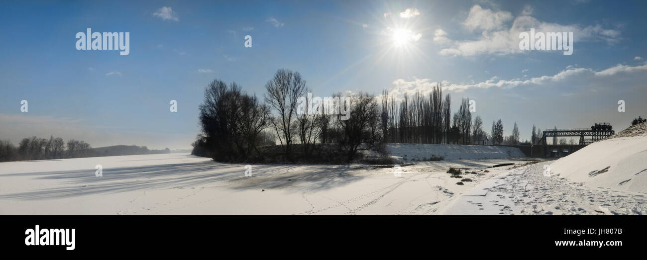 Panoramic photo of the frozen Tisa river covered with snow. Distant riverbanks veiled in mist. Stock Photo