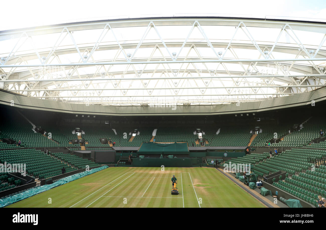 Ground staff cut the grass on centre court prior to the start of the action on day ten of the Wimbledon Championships at The All England Lawn Tennis and Croquet Club, Wimbledon. Stock Photo