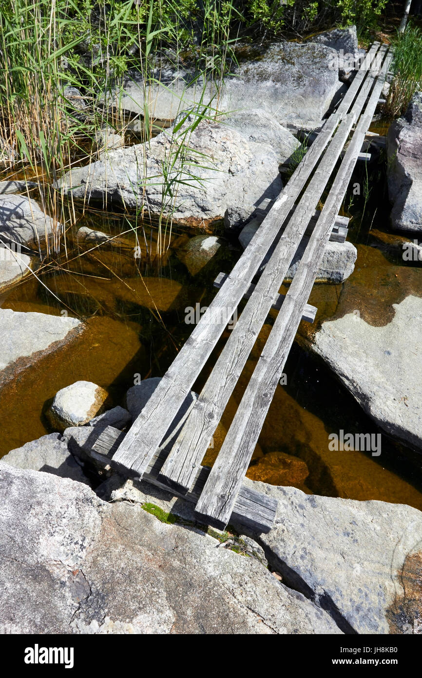 Makeshift wooden bridge over water Stock Photo - Alamy