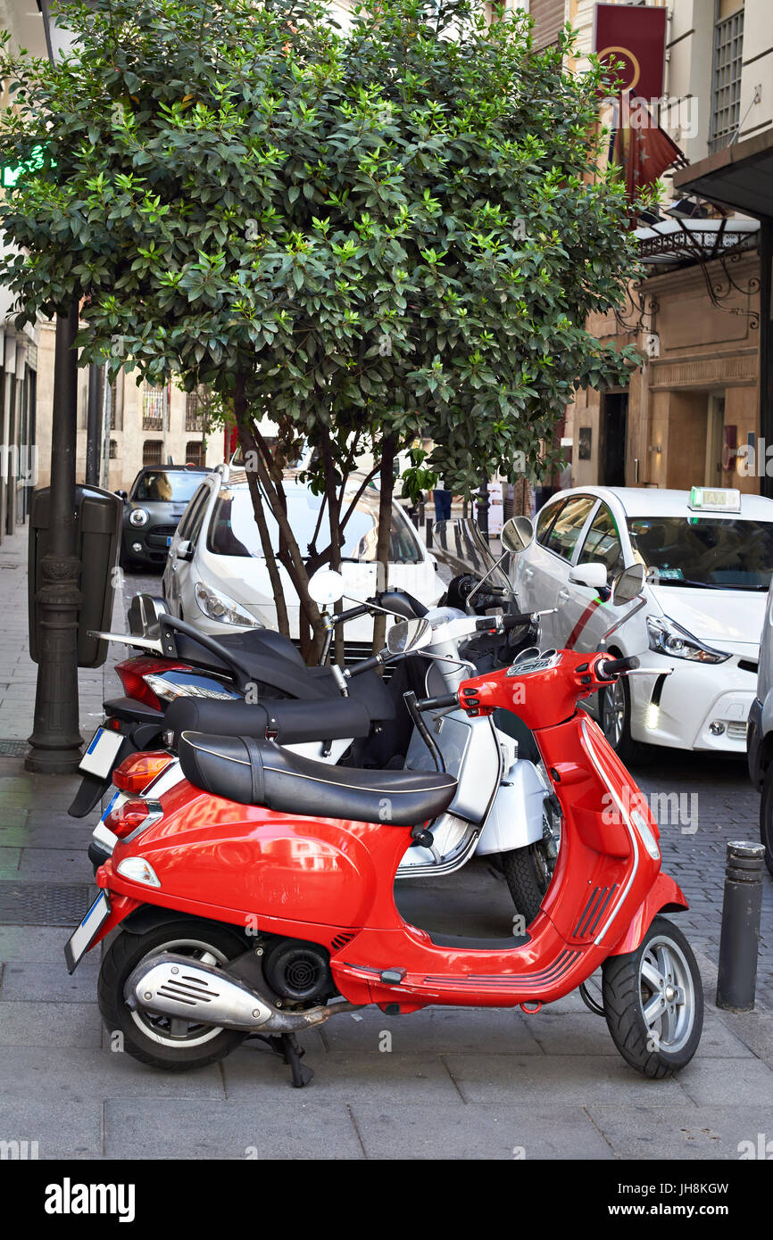 Red retro scooter on city street Stock Photo