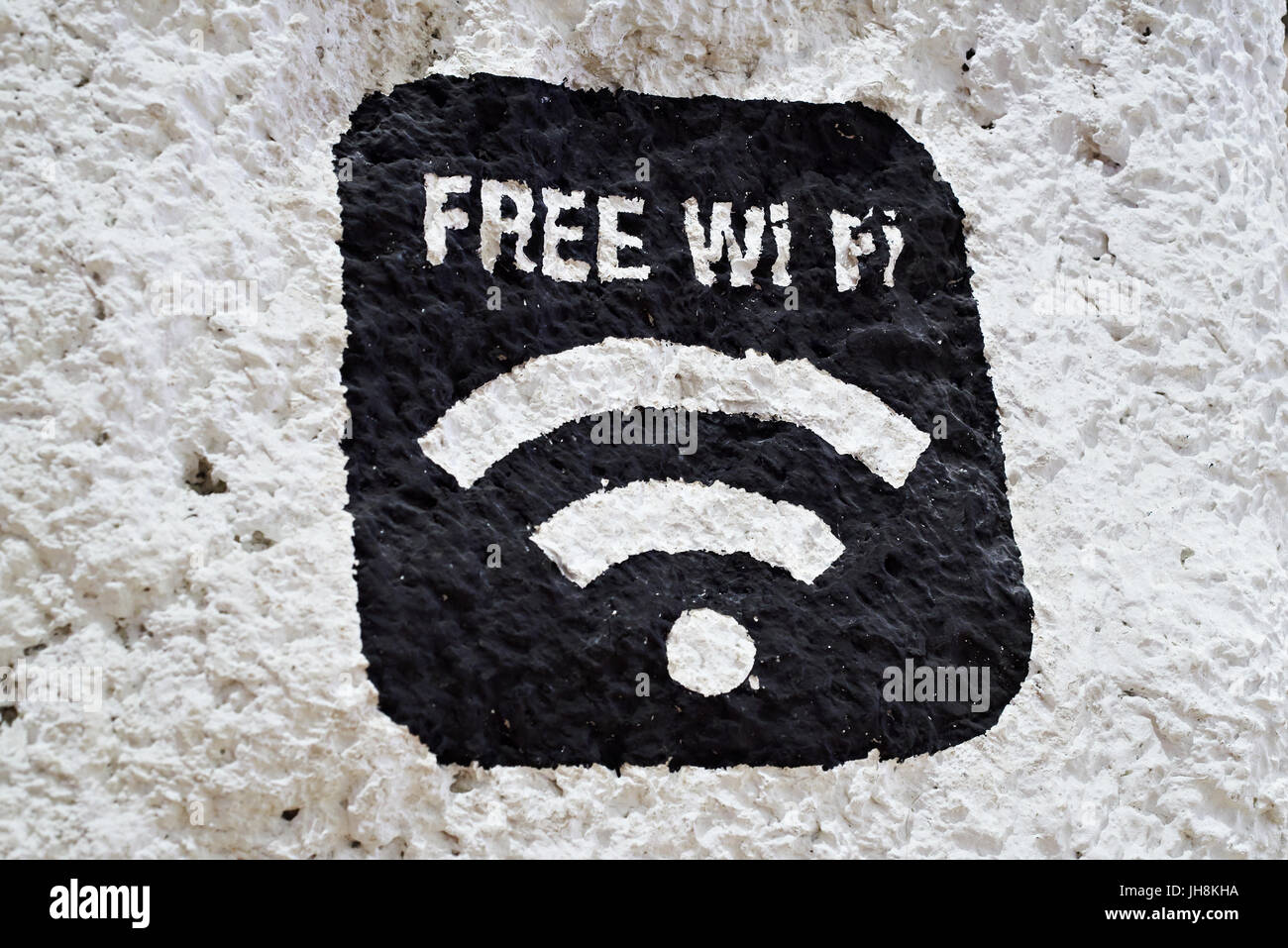 Black sign of free Wi-Fi on a white stone wall Stock Photo