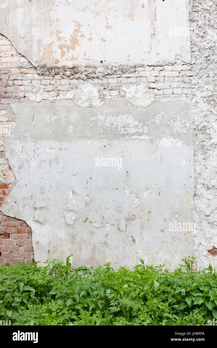 Aged brick wall with cracked plaster Stock Photo
