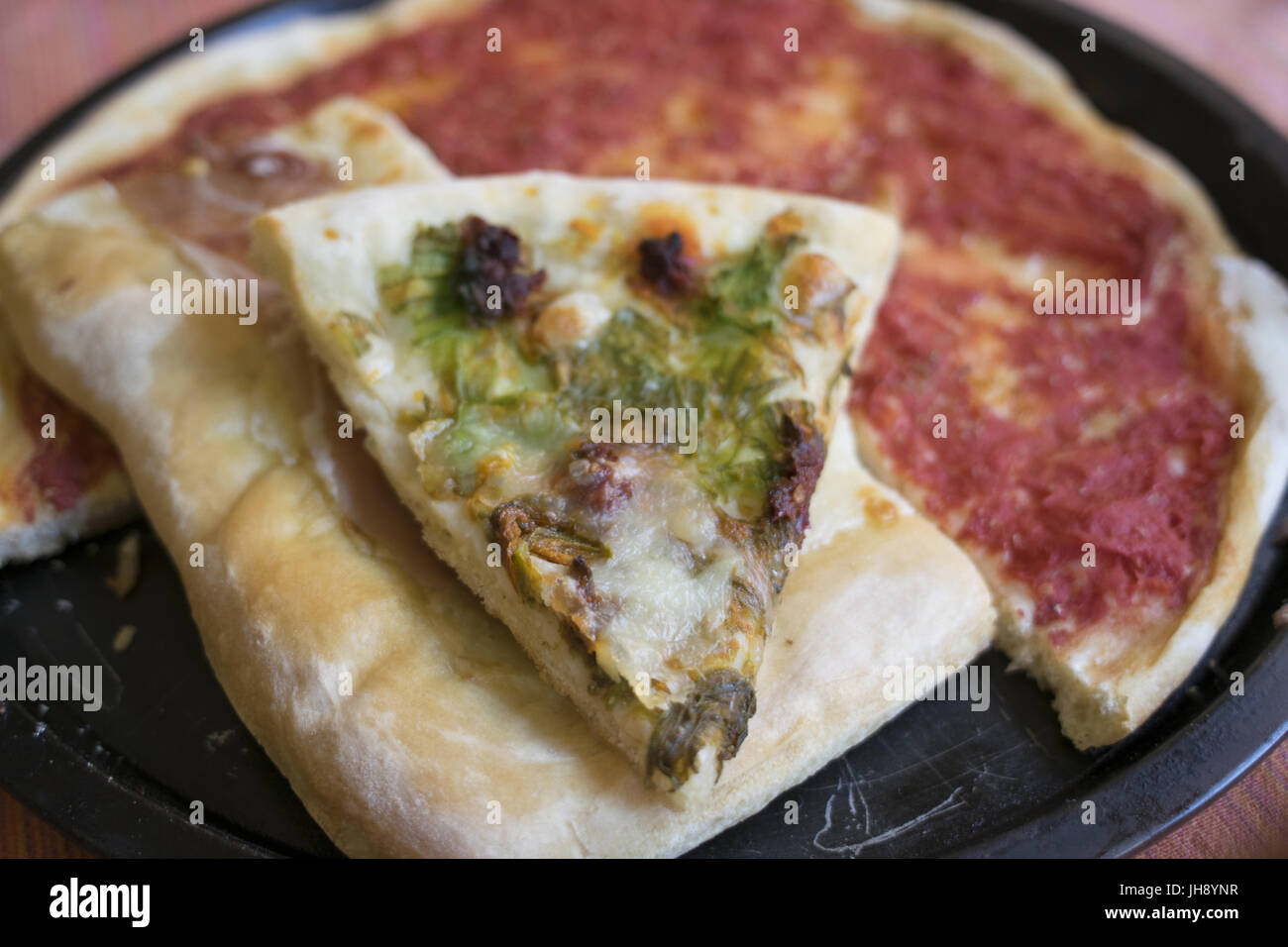 wedge of pizza made by hand with zucchini flowers and achovies Stock Photo