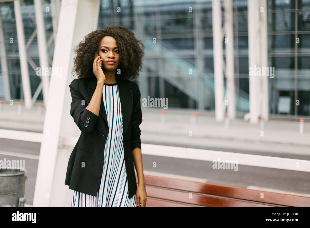 Close-up horizontal portrait of the beautiful serious afro-american girl talking via the mobile phone. Stock Photo
