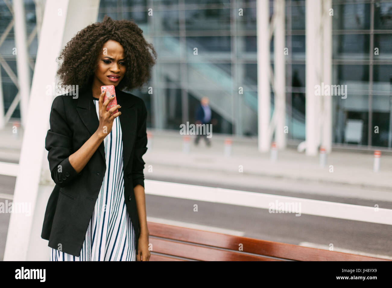 Close-up portrait of the sad afro-american woman talking on the mobile phone in the street. Stock Photo