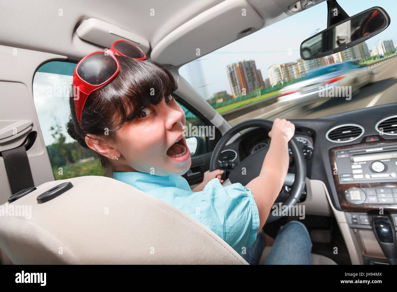 Woman in panic behind the wheel of the car. Driving lessons The woman