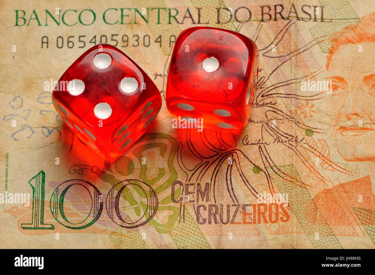 Red dices , calculator and old brazilian money note on a table Stock Photo