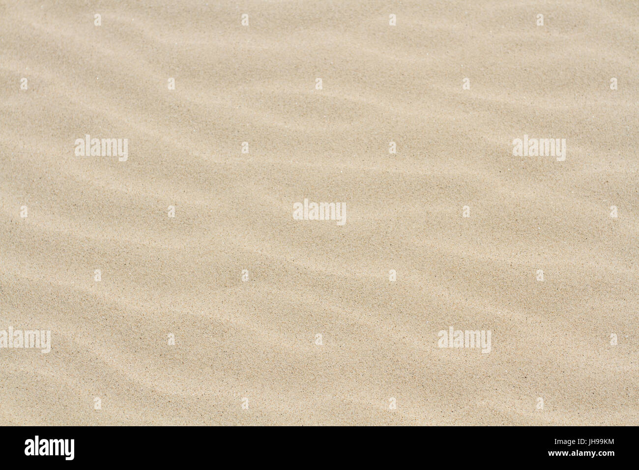 A full frame image of soft, Virgin sand with rippled effect in a beach or desert background image. Stock Photo