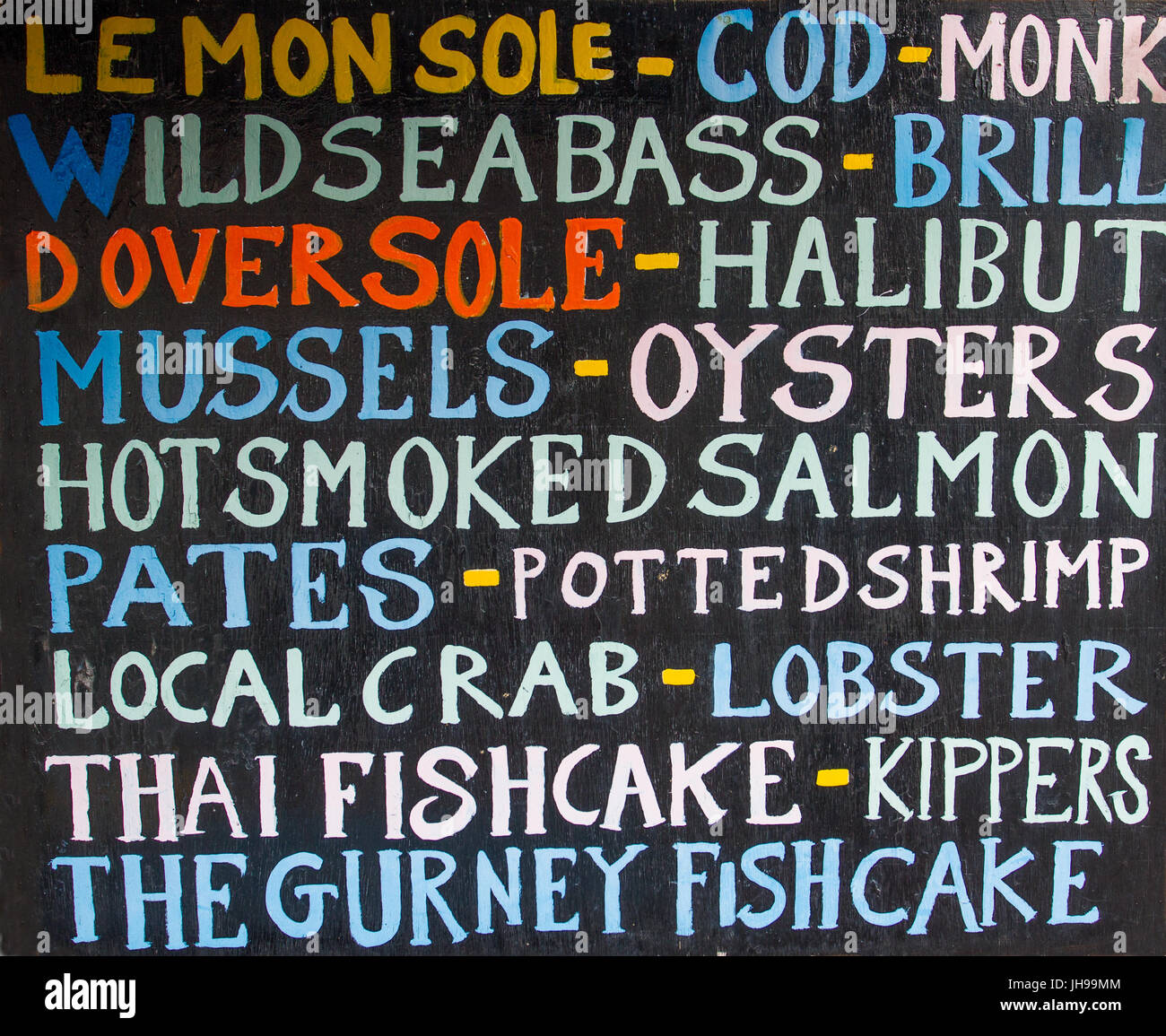The sign and blackboard outside a fresh fish shop showing the different variety of fish and seafood available for sale. Stock Photo