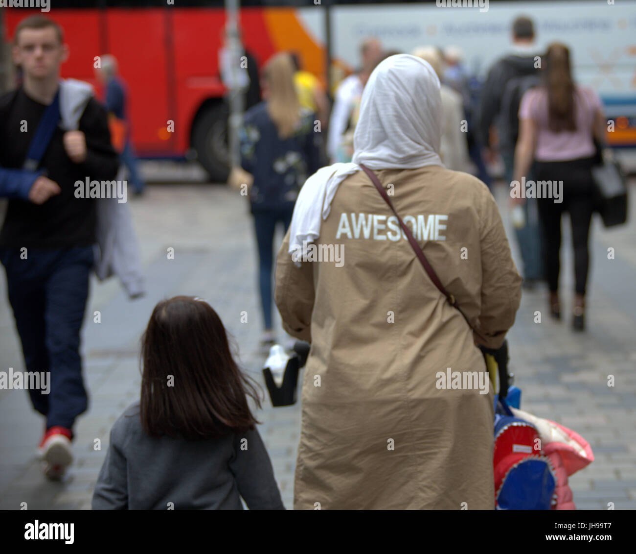 Asian family refugee young woman girl student pupil dressed Hijab scarf on street in the UK everyday scene walking on street awesome on back Stock Photo