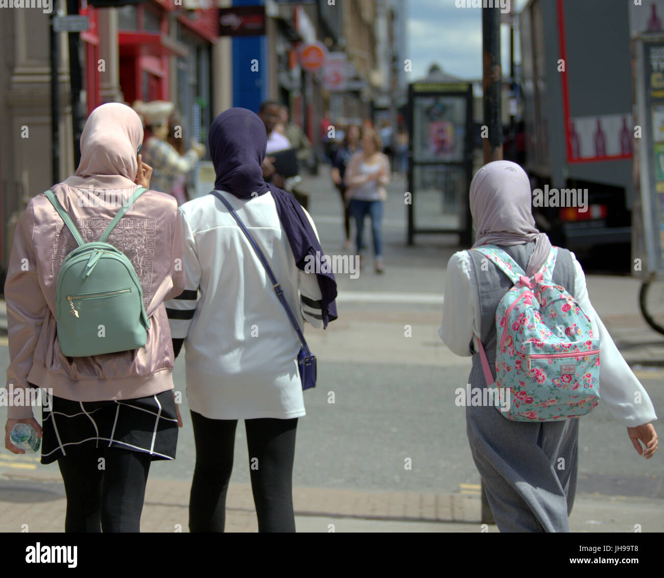 Asian family refugee young woman girl student pupil dressed Hijab scarf on street in the UK everyday scene walking on street Stock Photo