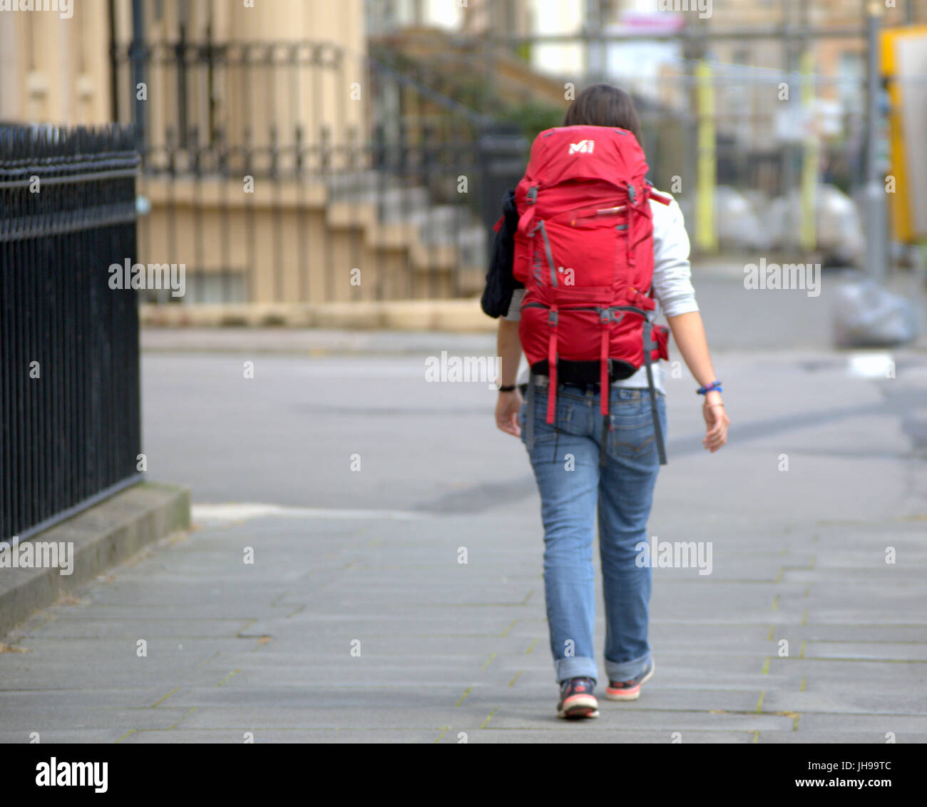 park circus youth hostel Glasgow young girl walking on street traveler tourist with rucksack from behind Stock Photo