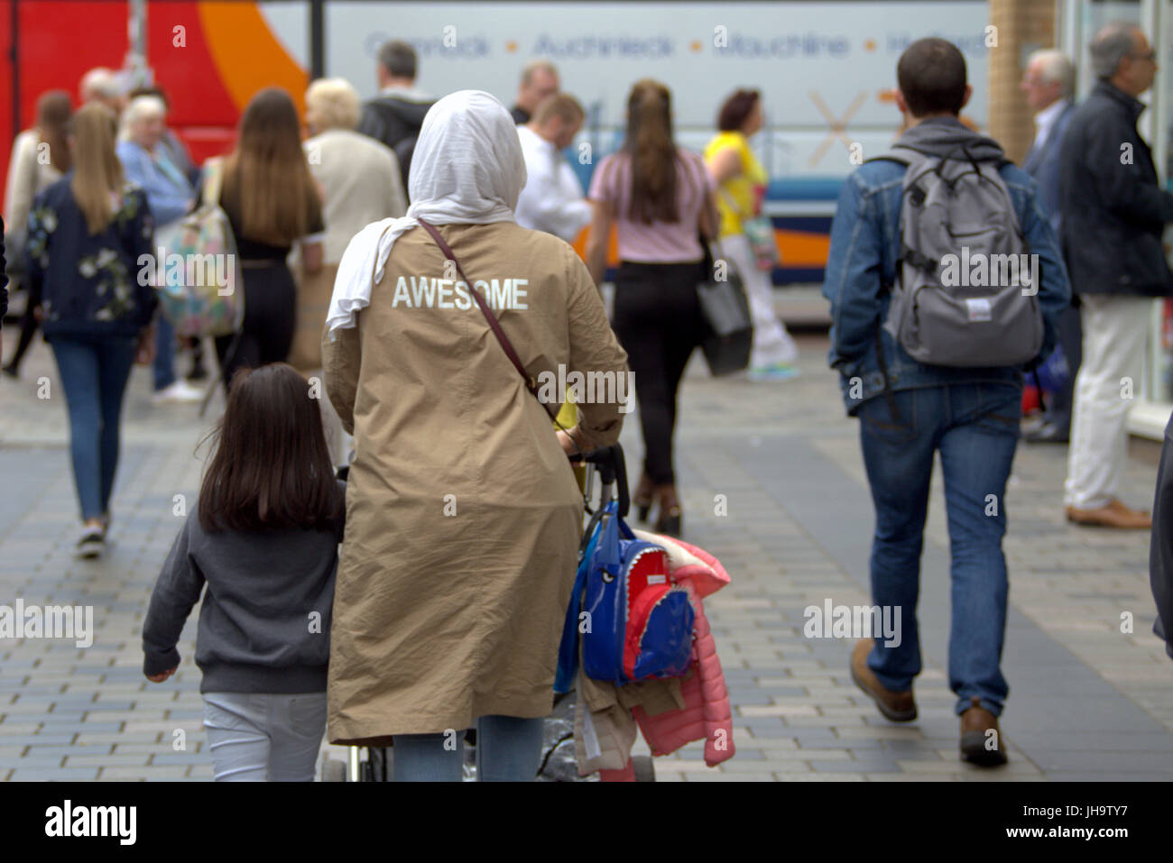 Asian family refugee young woman girl student pupil dressed Hijab scarf on street in the UK everyday scene walking on street awesome on back Stock Photo