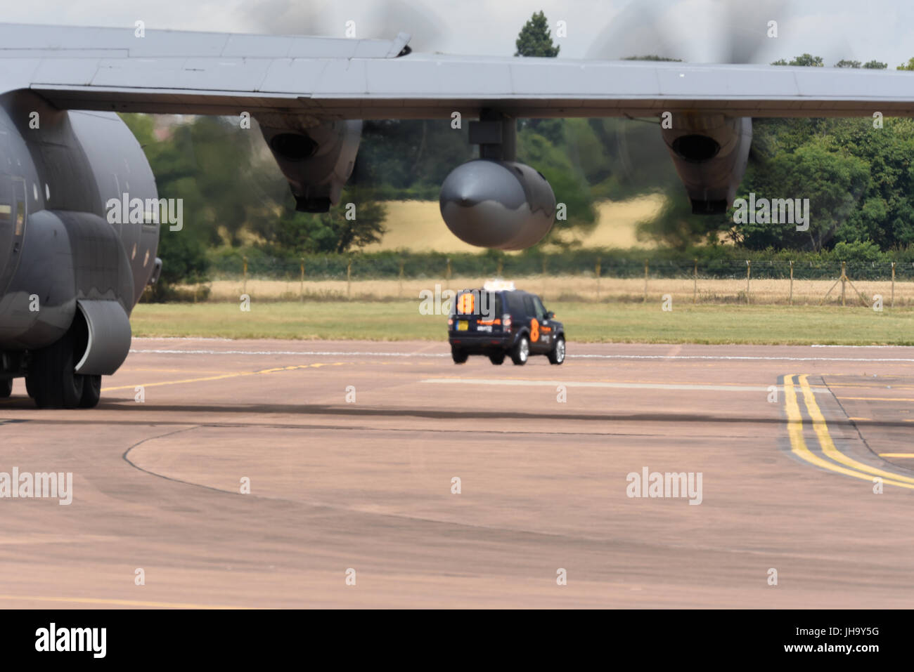 RAF Fairford in the picturesque Cotswolds hosts the Royal International Air Tattoo. C-130 Hercules following a follow me car Stock Photo