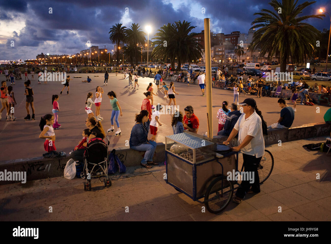 Skating, relaxing and drinking mate at sunset in the open skating rink El cuadrado, Motevideo, Uruguay. Stock Photo