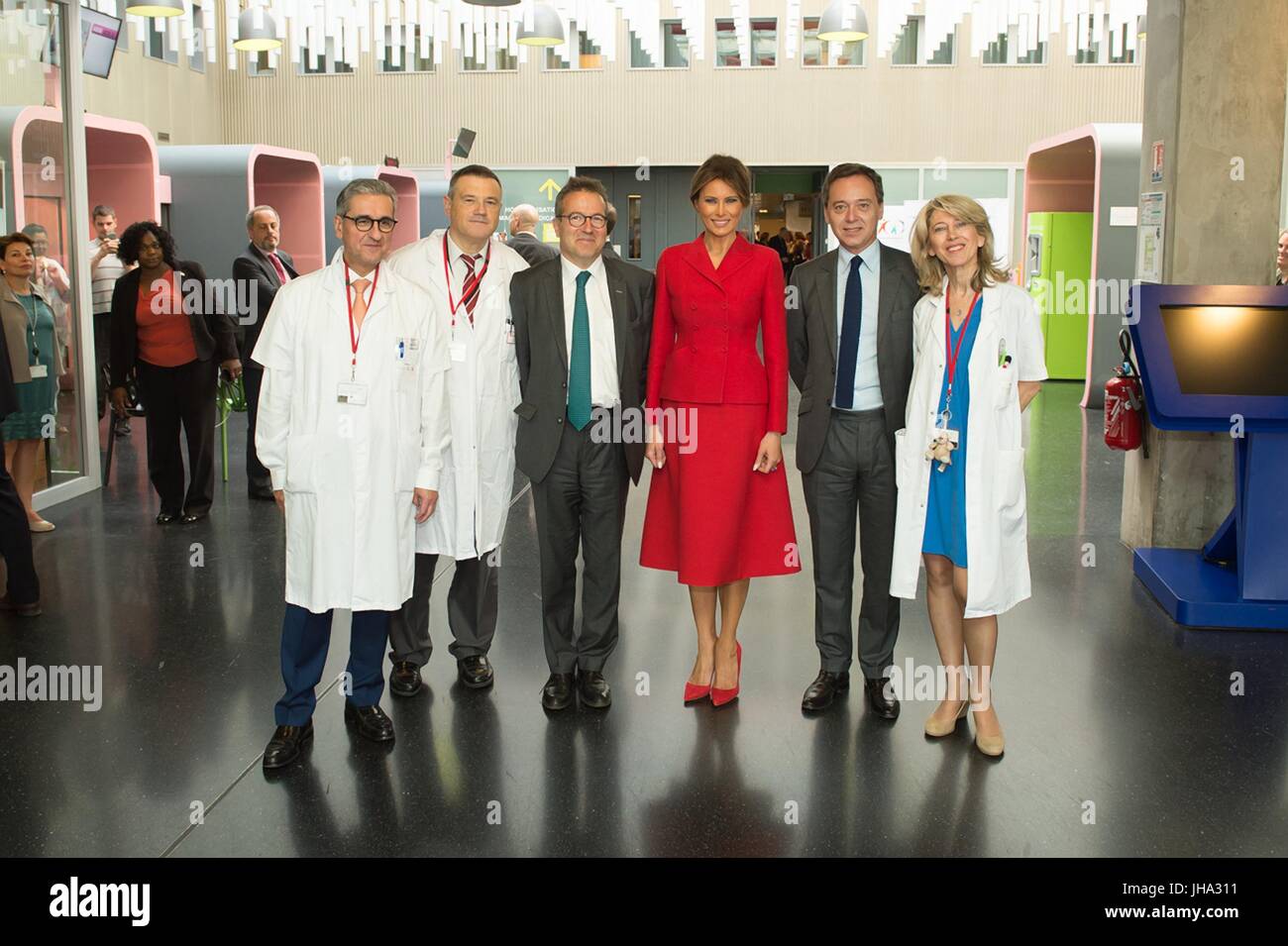 Paris, France. 13th July, 2017. U.S. First Lady Melania Trump, center, stands with doctors during a visit to Necker hospital, the largest pediatric hospital in France July 13, 2017 in Paris, France. The first lady paired a rare updo with a bright red Dior skirt suit and matching red pumps as she set off on her own schedule in Paris prior to Bastille Day celebrations. Credit: Planetpix/Alamy Live News Stock Photo