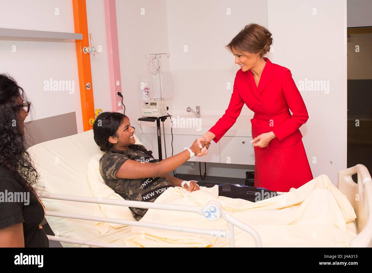 Paris, France. 13th July, 2017. U.S. First Lady Melania Trump greets a young patient during a visit to Necker hospital, the largest pediatric hospital in France July 13, 2017 in Paris, France. The first lady paired a rare updo with a bright red Dior skirt suit and matching red pumps as she set off on her own schedule in Paris prior to Bastille Day celebrations. Credit: Planetpix/Alamy Live News Stock Photo