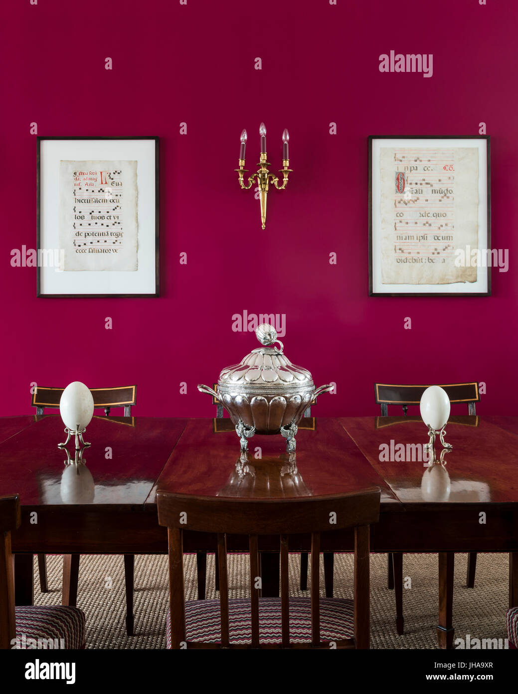 Ornaments On Wooden Dining Table With Red Wall Stock Photo
