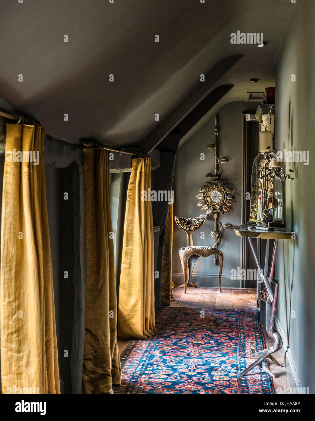 Hallway with yellow curtains and patterned rug Stock Photo