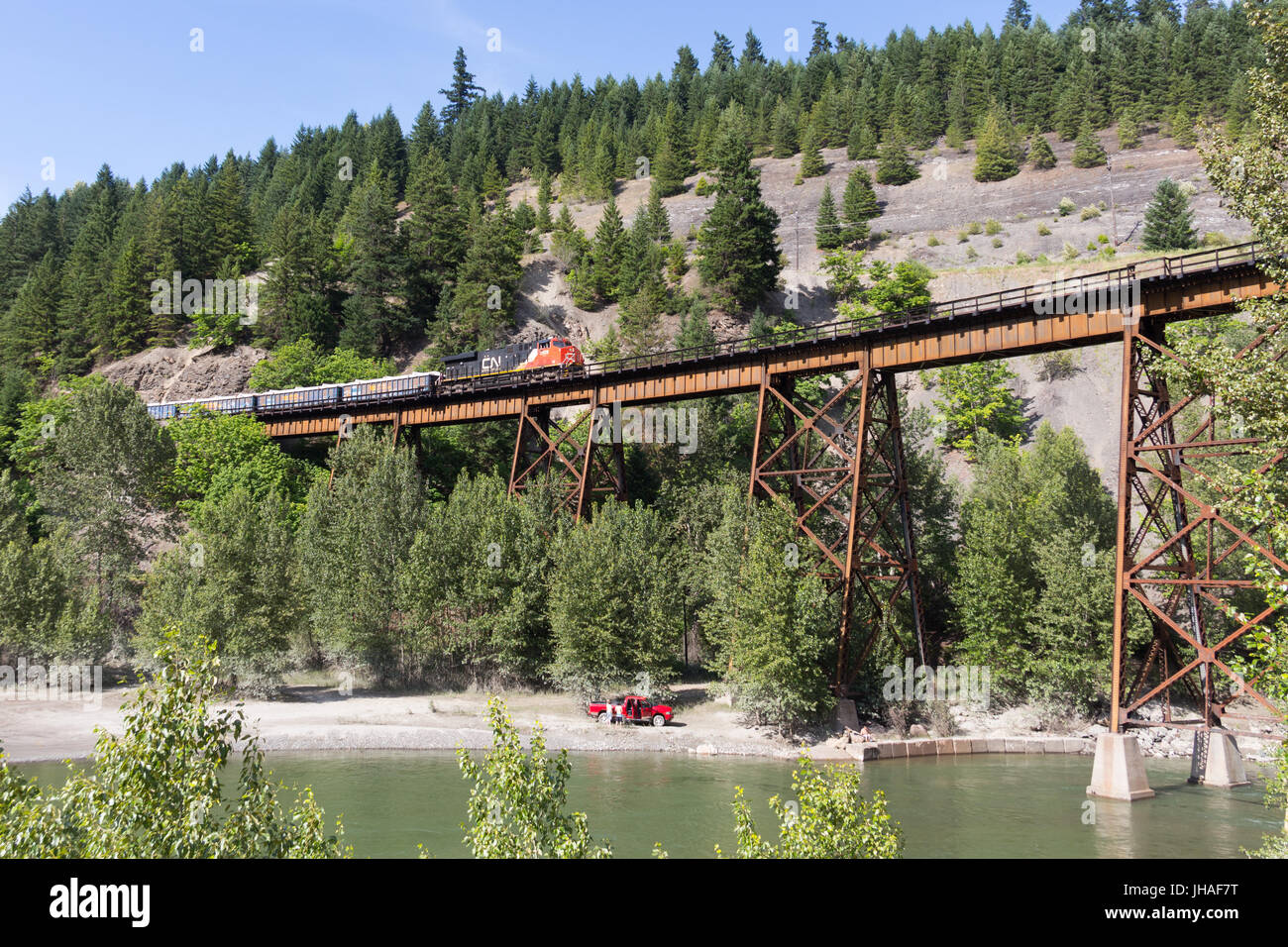 A train operated by CN Rail is crossing the Anderson Creek railway bridge in the Fraser Canyon near Boston Bar, British Columbia, Canada Stock Photo