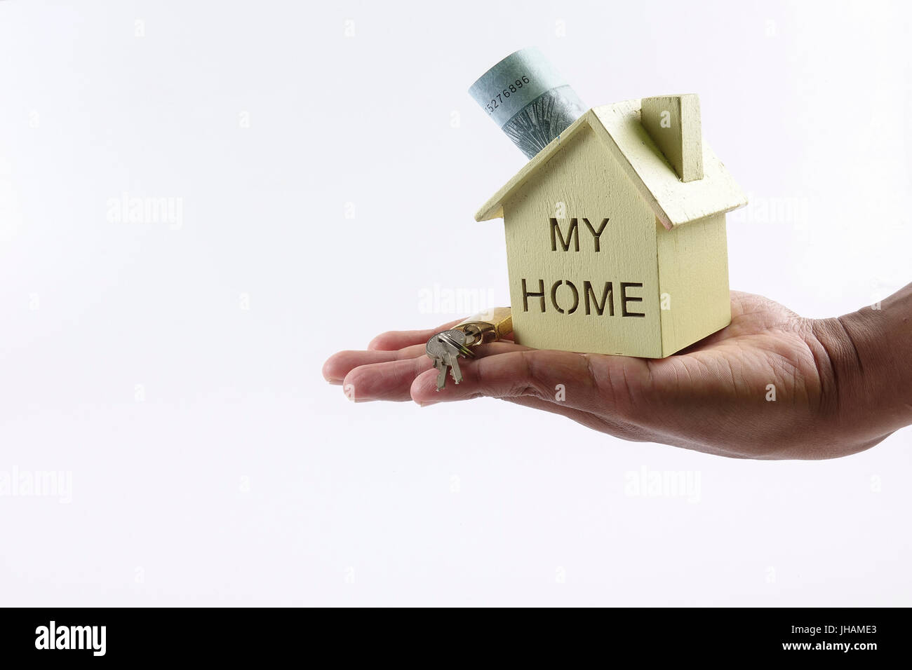 Housing loan concept. Small house and coin isolated on white background. Copy space Stock Photo