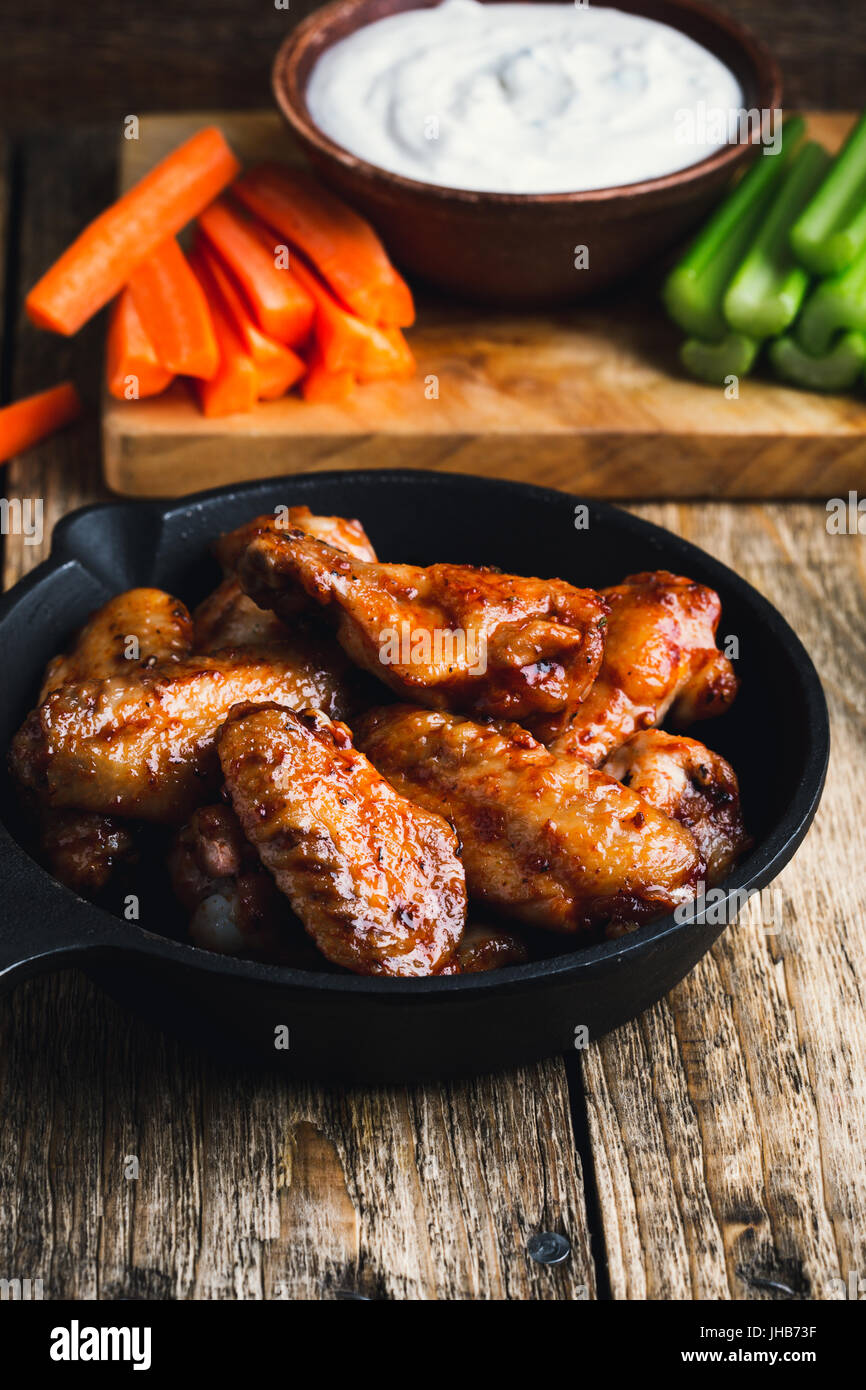 Roasted chicken wings with carrots, celery and dipping sauce on rustic
