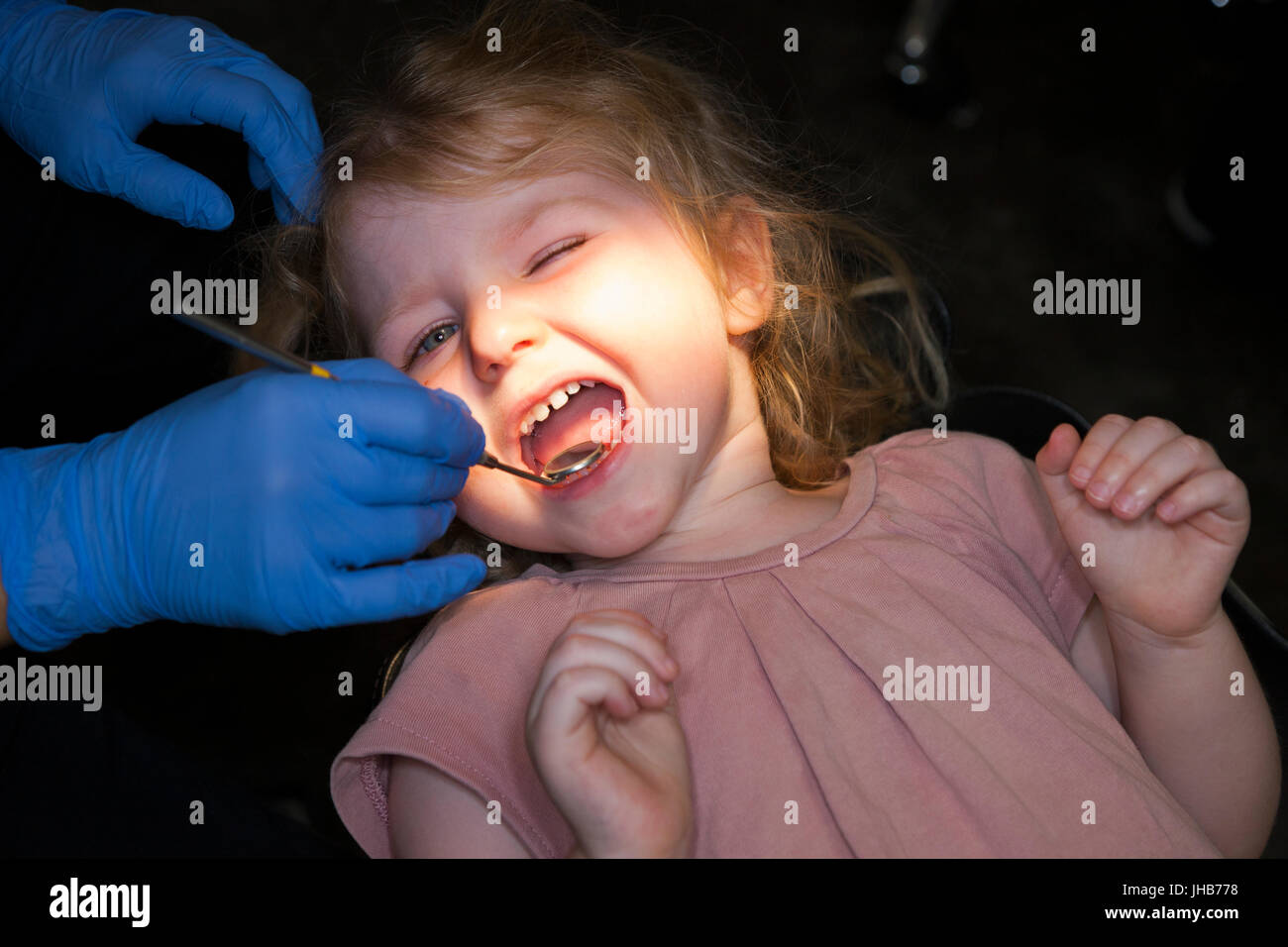 Toddler girl / 2 or 3  yr / two or three year old child during check up with childrens dentist / children's dental practice. UK Stock Photo