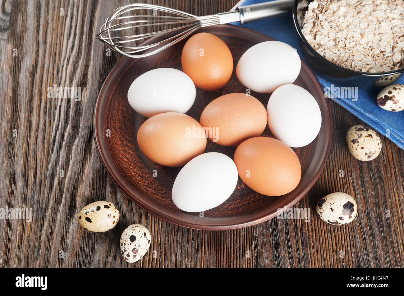 Quail and chicken eggs in a clay plate on a wooden background Stock ...