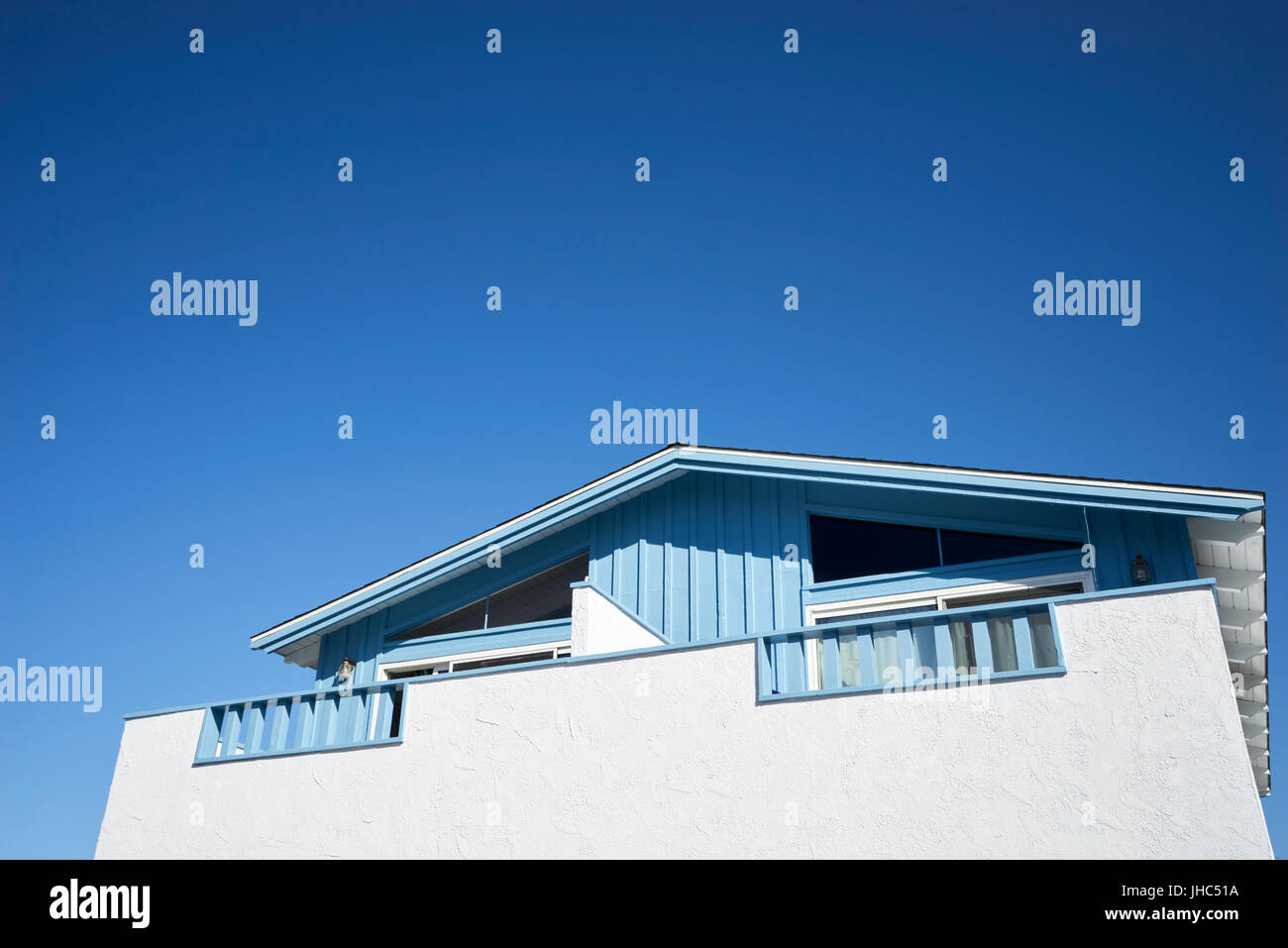 White & baby blue wood and plaster bungalow; expansive sky Stock Photo