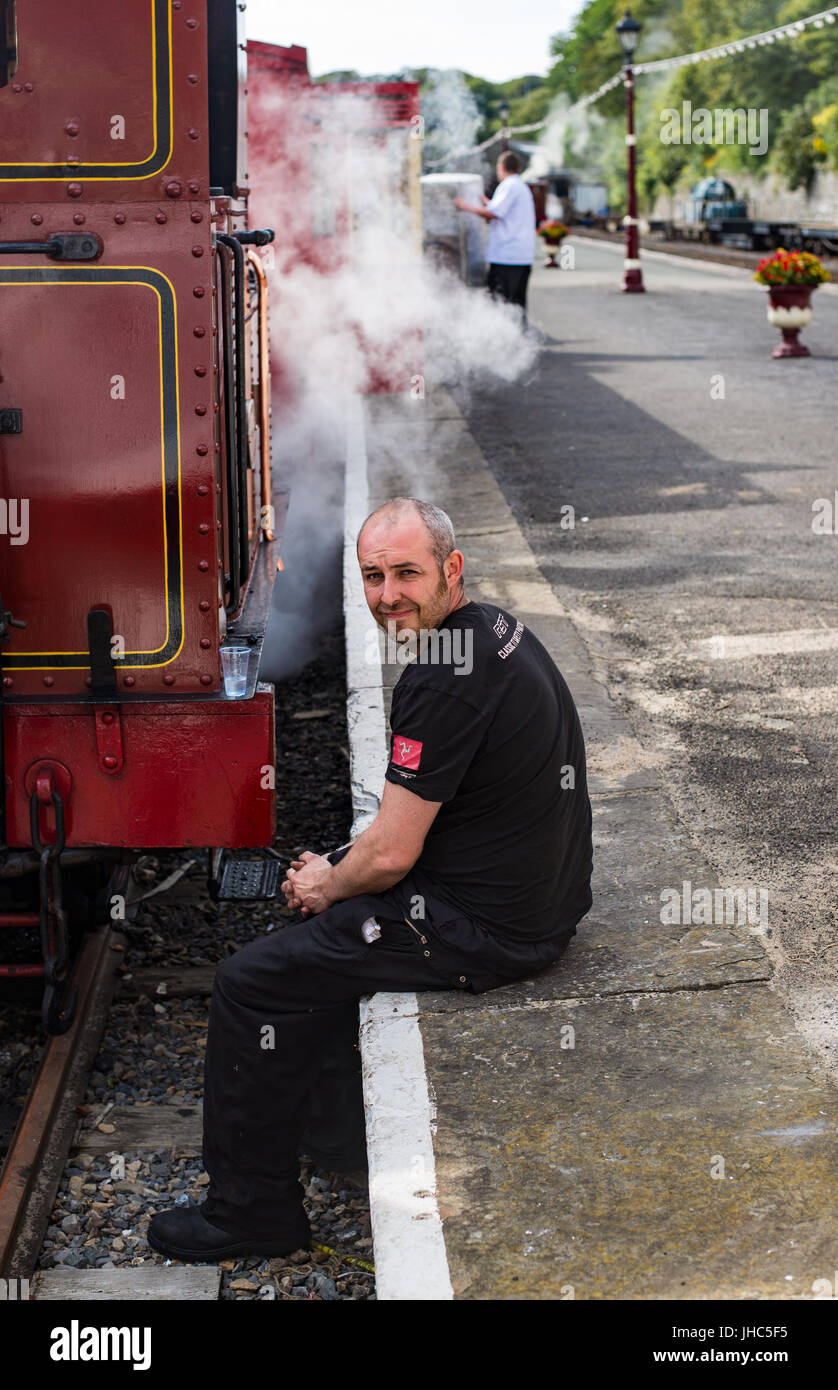 Train guard having a break on Douglas platform, Manx victorian train Stock Photo