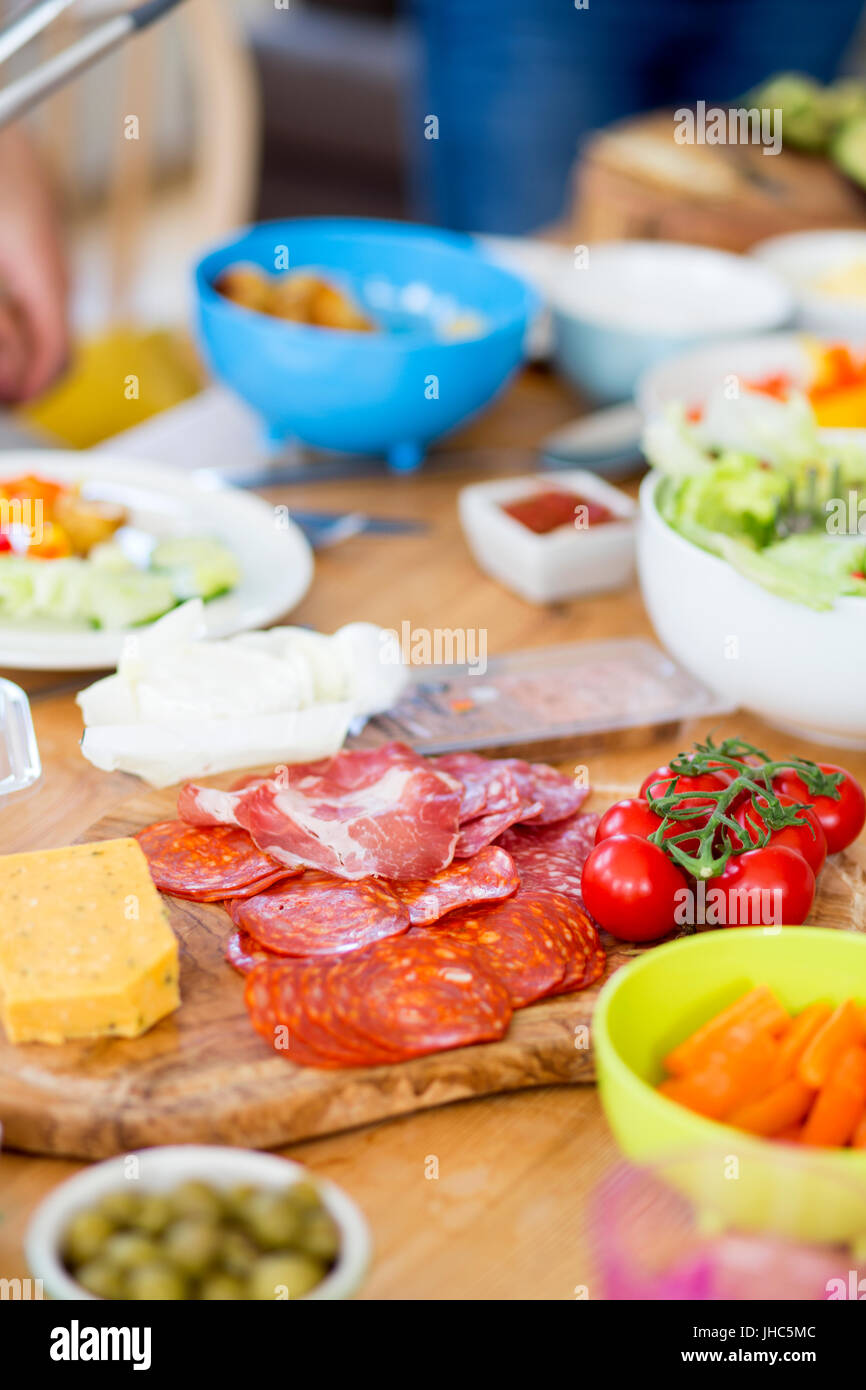 Mediterranean style food on a table including cured hams, cheeses, tomatoes and salad Stock
